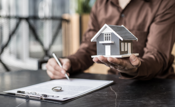 Hand holding a house. Analyzing a contract.